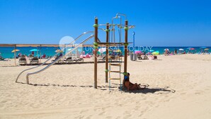 Une aire de jeux de plage avec un toboggan et une structure d’escalade.
