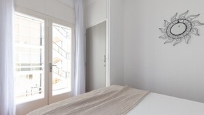 Une chambre à coucher avec un lit, une fenêtre avec des rideaux et un objet décoratif fixé au mur.