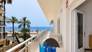 Un balcon avec vue sur la plage, les palmiers et la mer.