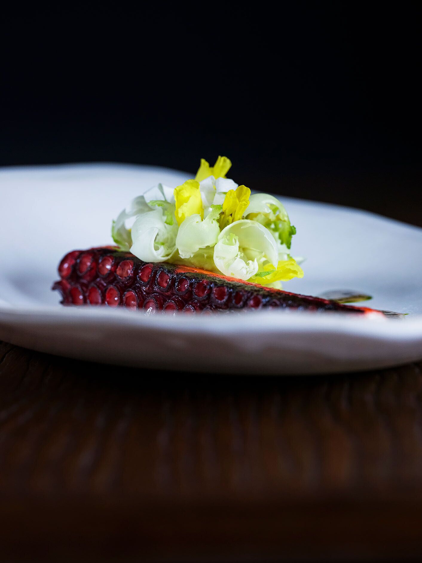 A plate with a food item, possibly a dish with a garnish of green and yellow leaves.