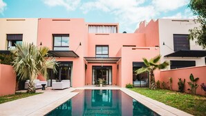 Ein modernes Gebäude mit Schwimmbad, Außenbereich und gepflegtem Garten.