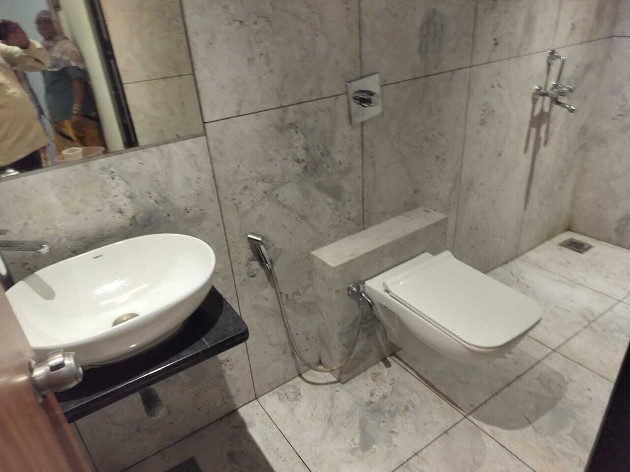 Un baño con lavamanos, inodoro y ducha blancos.