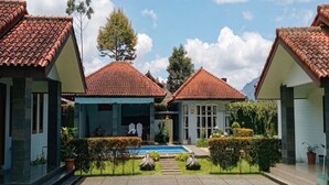 A courtyard with a swimming pool, surrounded by buildings with red-tiled roofs. - Cozzy Villa Mandala Wangi Pangalengan (Pangalengan)