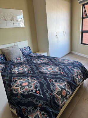 A bedroom with a bed, a wardrobe, and a window. - Spacious 3-bedroom beach apartment in gorgeous Durban's Point waterfront with AC (Durban)