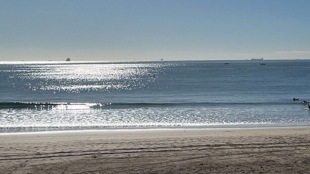 Una spiaggia con cielo sereno e mare calmo.