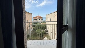 Un balcón con vista a edificios y un cielo despejado.