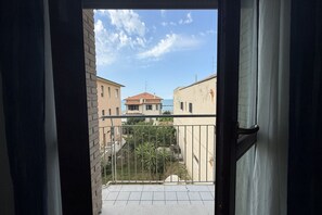 Un balcon avec vue sur les immeubles et un ciel dégagé.