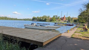 A wooden dock extending into a calm body of water with boats moored nearby. - Klonova Apartment in Masuria (Olecko)