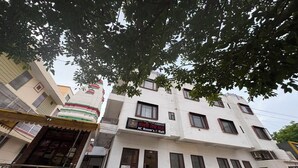 A multi-story building with a sign for 'AC Room's & Hall' indicating a hotel or accommodation facility. - Gayatri Seva Dham (Vrindavan)