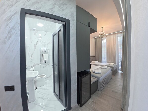 Une salle de bain moderne avec une douche à parois de verre, des toilettes et un lavabo.