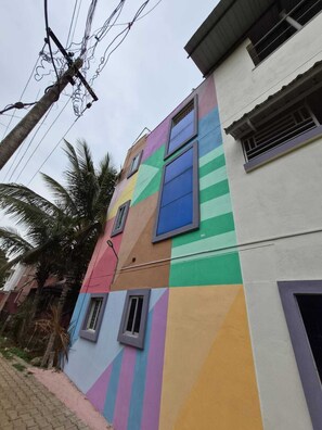 A multi-story building with colorful geometric patterns on the facade, multiple windows, and a visible power line.