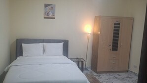 Une chambre à coucher avec un lit, une armoire et un tableau accroché au mur.