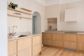 A modern kitchen with wooden cabinets, a stainless steel sink, and a built-in oven. - Historic Central Pyynikki 3BR Apt. Free Parking. (Tampere)
