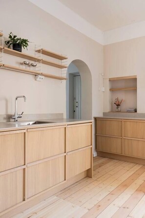 Eine moderne Küche mit Holzausstattung, einer integrierten Spüle und einer Arbeitsplatte.