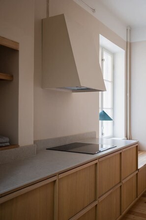 A modern kitchen with a built-in stove, wooden cabinets, and a window with a view. - Historic Central Pyynikki 3BR Apt. Free Parking. (Tampere)