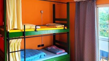 Un letto a castello con struttura verde, una piccola scrivania e una finestra con tende.