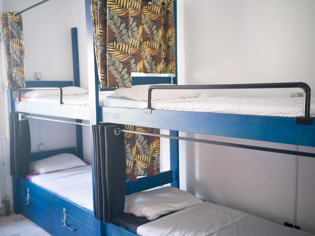 Camera con letto a castello, tende, una finestra e ripiano a parete.