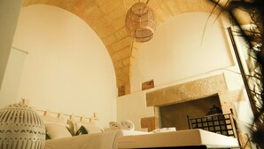 Quarto com cama, luminária pendente e vista para o exterior.