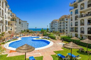 A resort with a central swimming pool, multiple balconies, and a view of the ocean. - Sea Views Apartment with Terrace and Pools (Puerto de la Duquesa)