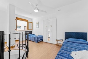 A bedroom with two beds, a ceiling fan, and a wardrobe. - Sea Views Apartment with Terrace and Pools (Puerto de la Duquesa)
