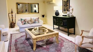 Un salon comprenant un canapé, une table basse, un meuble et un miroir.