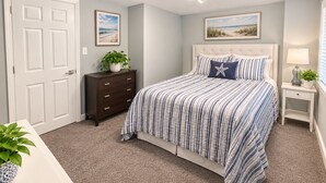 A bedroom with a bed, a dresser, a nightstand, and a door. - Beach Casita 1-bedroom Apt by Boardwalk and Beach (Ocean City)