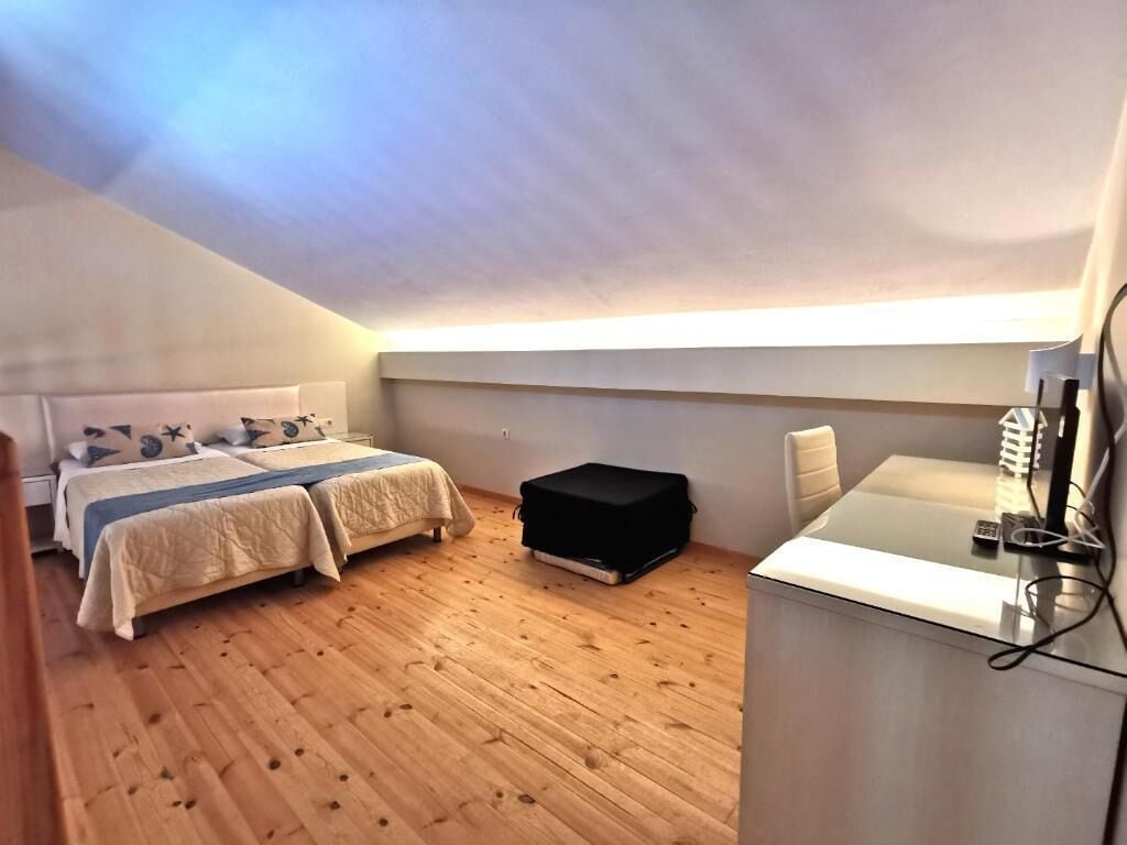 Ein Schlafzimmer mit zwei Betten, einem Schreibtisch und einem Stuhl.