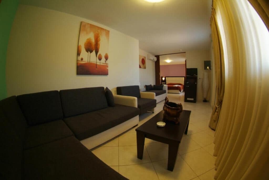 Una sala de estar con un sofá, una mesa de centro y un cuadro en la pared.