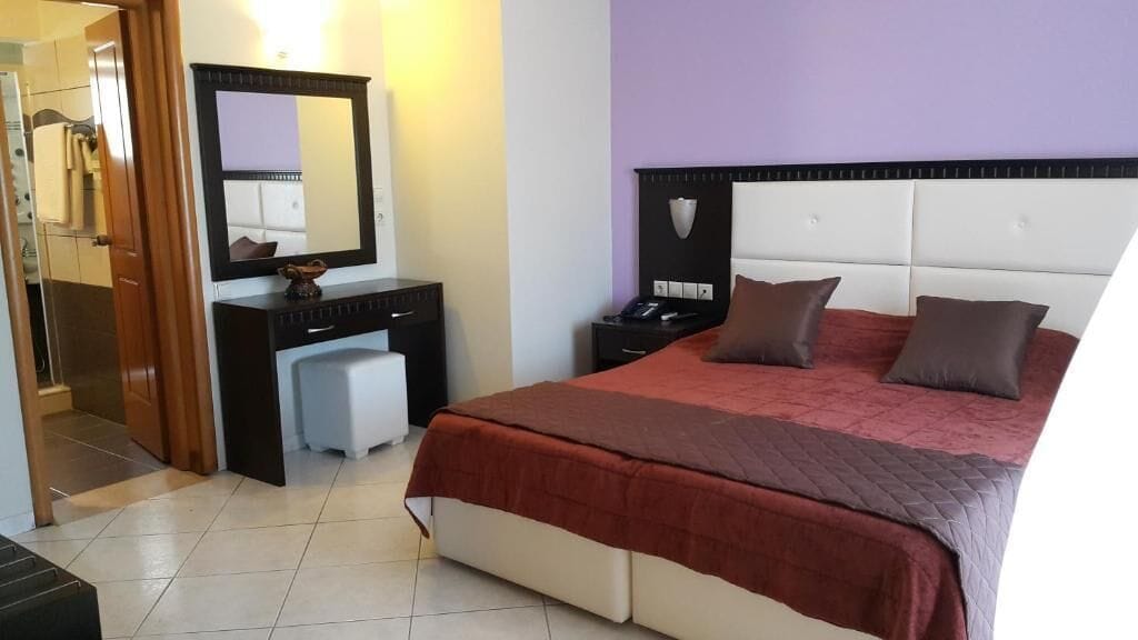 Un dormitorio con una cama, mesitas de noche, un aparador y un espejo.