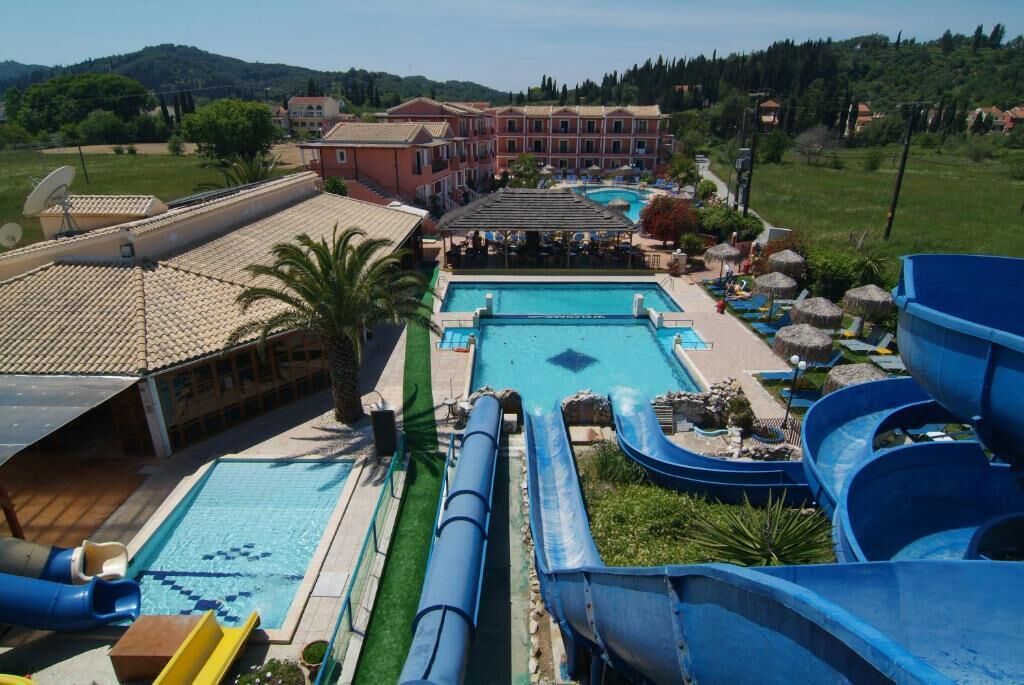 Ein Resort mit Schwimmbad, Wasserrutschen und einem Gebäude mit Balkonen.