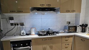 A modern kitchen with a built-in oven, microwave, and gas stove. - Cozy Gardens View Palace Apartment (Nairobi)