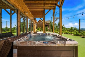 Ein Whirlpool unter einer Holzw pergola mit Blick auf eine Berglandschaft.