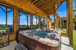A wooden spa area with a hot tub, large windows, and a view of the outdoors. - 6 Bedrooms with Mini Golf - Indoor Waterfall Pool - Awesome Views! (Sevierville)