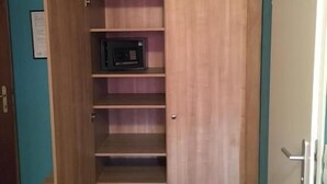 Un armario de madera con varios estantes y un microondas.