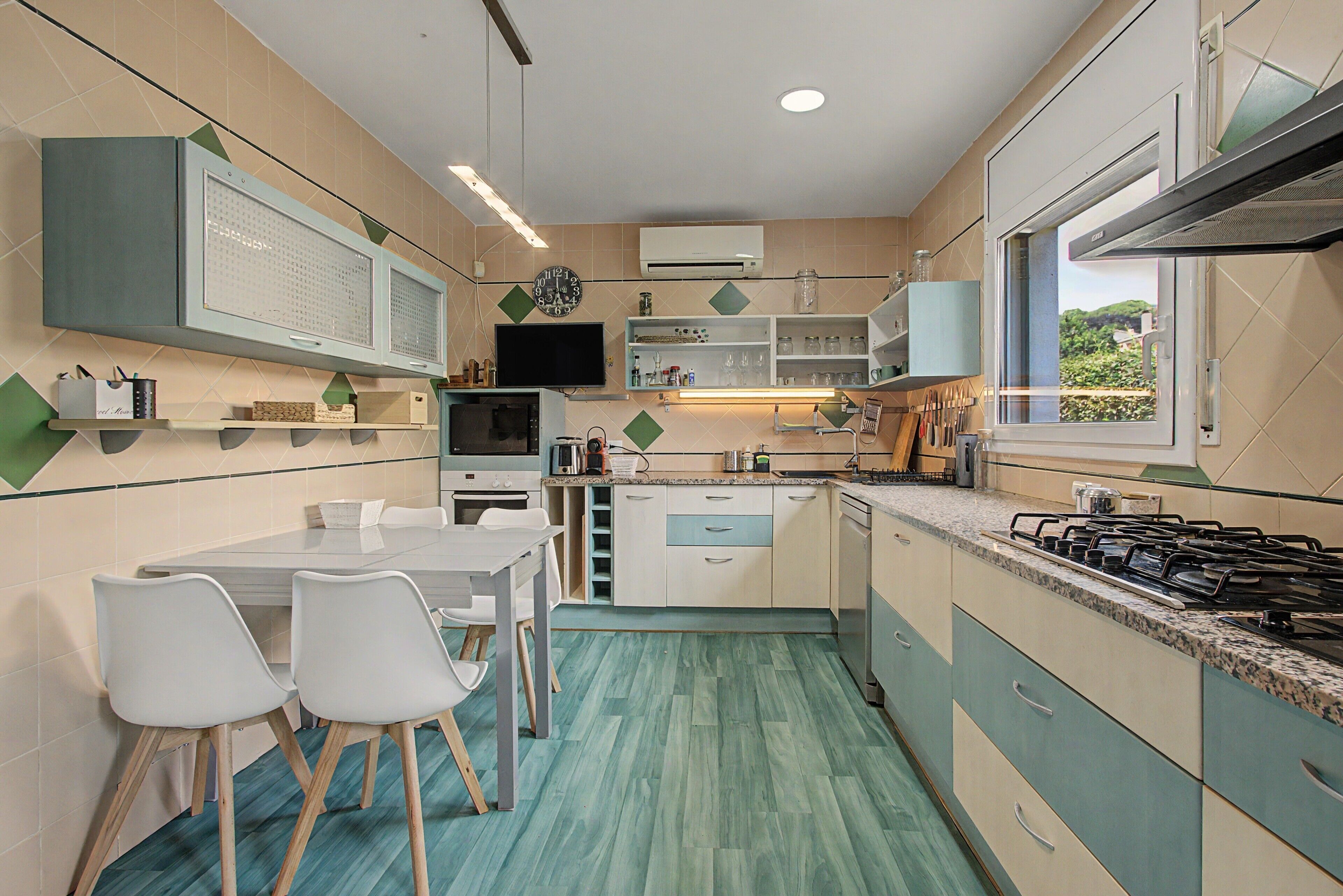 A compact kitchen with a dining area, equipped with a stove, microwave, and cabinets.