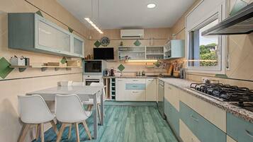 A compact kitchen with a dining area, equipped with a stove, microwave, and cabinets.