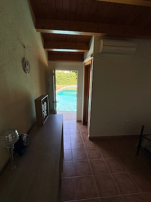 Una habitación con vista a una piscina visible a través de un umbral abierto.