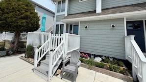 A two-story house with a front porch, a staircase, and a small garden area. - 3 bedroom 2.5 bath Townhome just a few short blocks to the beach. (Wildwood Crest)