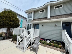 A two-story house with a front porch, a staircase, and a small garden area. - 3 bedroom 2.5 bath Townhome just a few short blocks to the beach. (Wildwood Crest)
