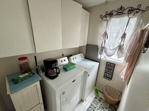 A compact laundry area with a washing machine, a coffee maker, and a pet wipes dispenser. - 3 bedroom 2.5 bath Townhome just a few short blocks to the beach. (Wildwood Crest)