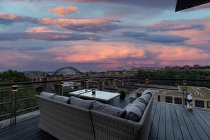 Eine Dachterrasse mit Blick auf eine Brücke und Gebäude.