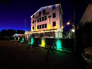 A building with the sign 'SAIR OTEL' at night, featuring a balcony with bicycles and string lights. - çayır otel (Marmara Ereglisi)