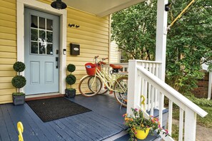 A yellow house with a blue door, a porch with a white railing, a bicycle, and a mailbox. - Near Wineries | Sleeps 9 | Walking distance to Geneva (Geneva)