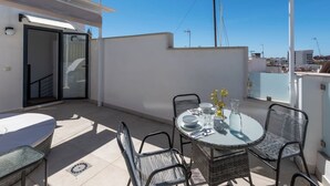 A rooftop terrace with a round table, chairs, and a sofa. - Old Town Estepona Penthouse (Estepona)