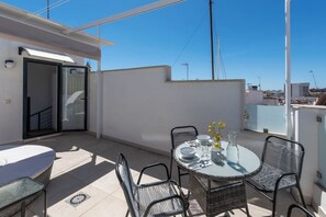 A rooftop terrace with a round table, chairs, and a sofa. - Old Town Estepona Penthouse (Estepona)