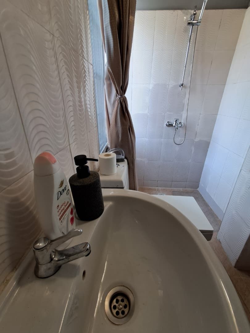 Une salle de bain équipée d’un lavabo, d’une douche et d’articles de toilette.