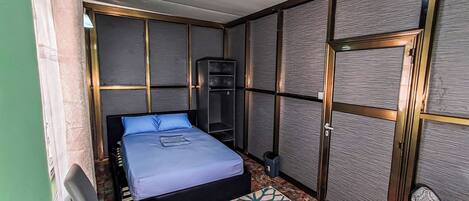 Un dormitorio con cama, escritorio, silla y armario.
