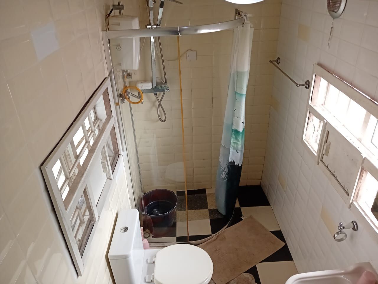 Un bagno con il water, un lavandino, una doccia e un catino.