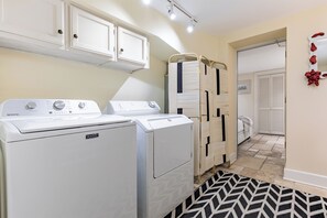 A laundry room with two white Mavtag washing machines, a drying rack, and a door leading to another room. - Best Location Near Madison Square, Walk Everywhere by Lucky Savannah (Savannah)