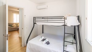 A bunk bed with a mattress and pillows, a rolled towel, and a small table with a chair. - Cubo's Miralmonte Rural House / Private pool / Air conditioning / BBQ (Coín)